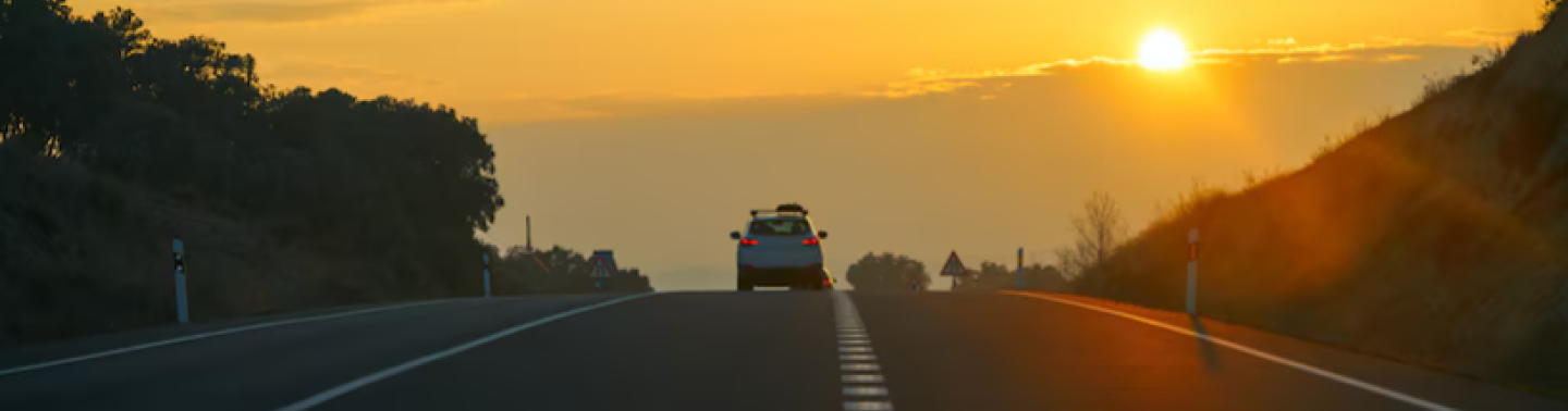 Voiture prenant le large sur fond de coucher de soleil